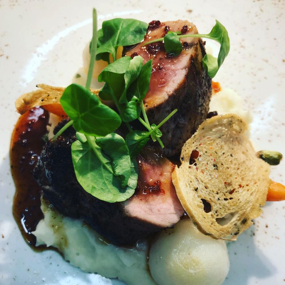 A dish containing meat and potatoes, arranged neatly on a plate, ready to be enjoyed.