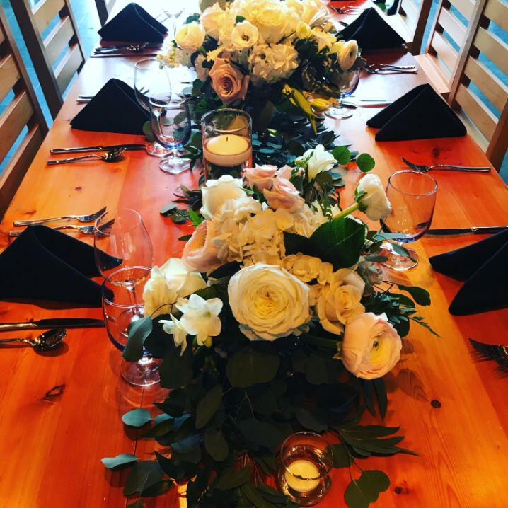 A decorative table featuring an assortment of colorful flowers and glowing candles, enhancing the ambiance of the setting.