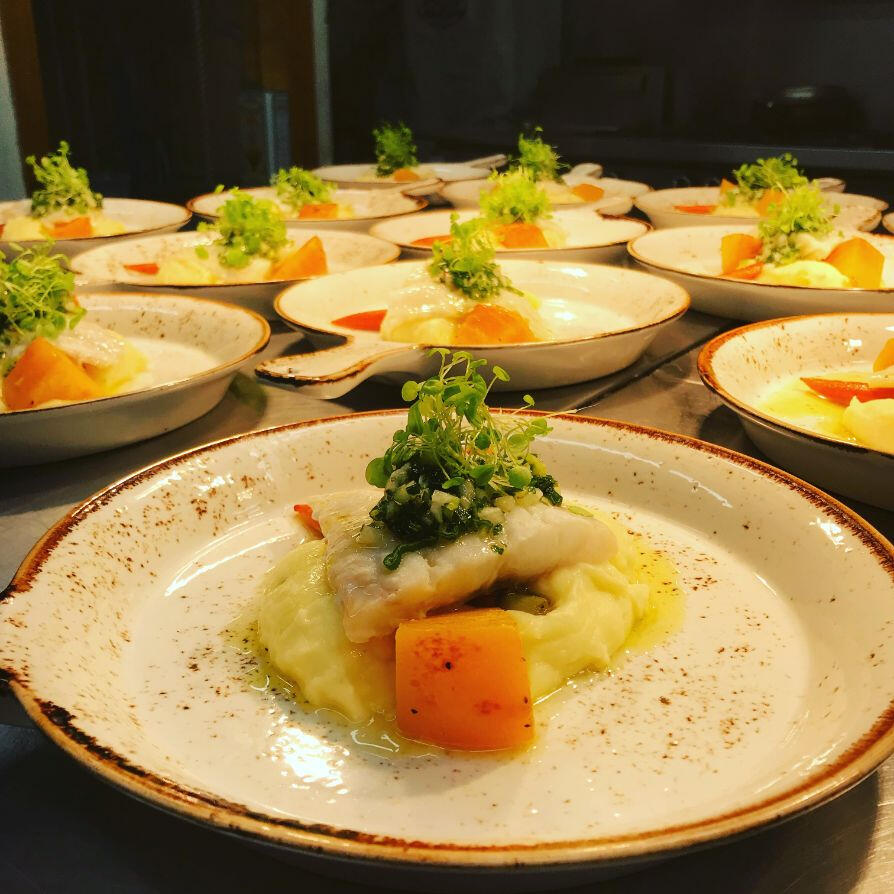 A large assortment of plates filled with various types of food arranged neatly on a table.