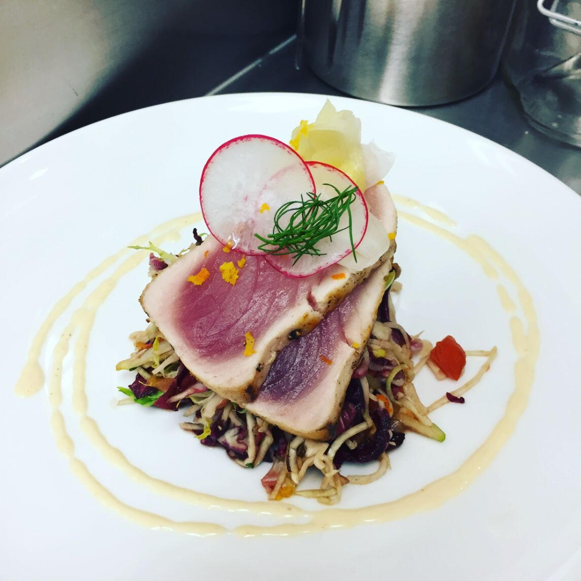 A plate featuring a succulent piece of tuna accompanied by vibrant radishes, elegantly arranged for presentation. A plate featuring a succulent piece of tuna accompanied by vibrant radishes, elegantly arranged for presentation.